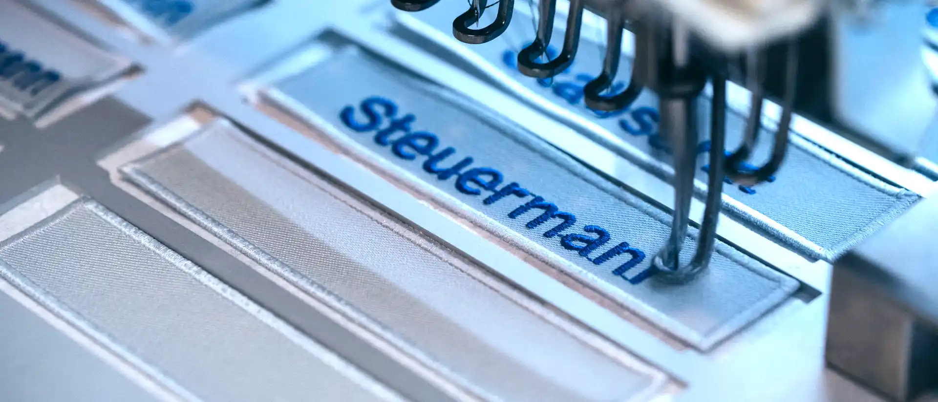 Self-adhesive backing with positioned name badges in a stencil frame